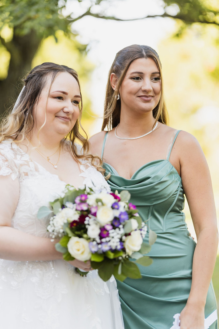 Hochzeit Kloster Wiblingen: Braut mit Freundin im grünen Kleid beim Sektempfang