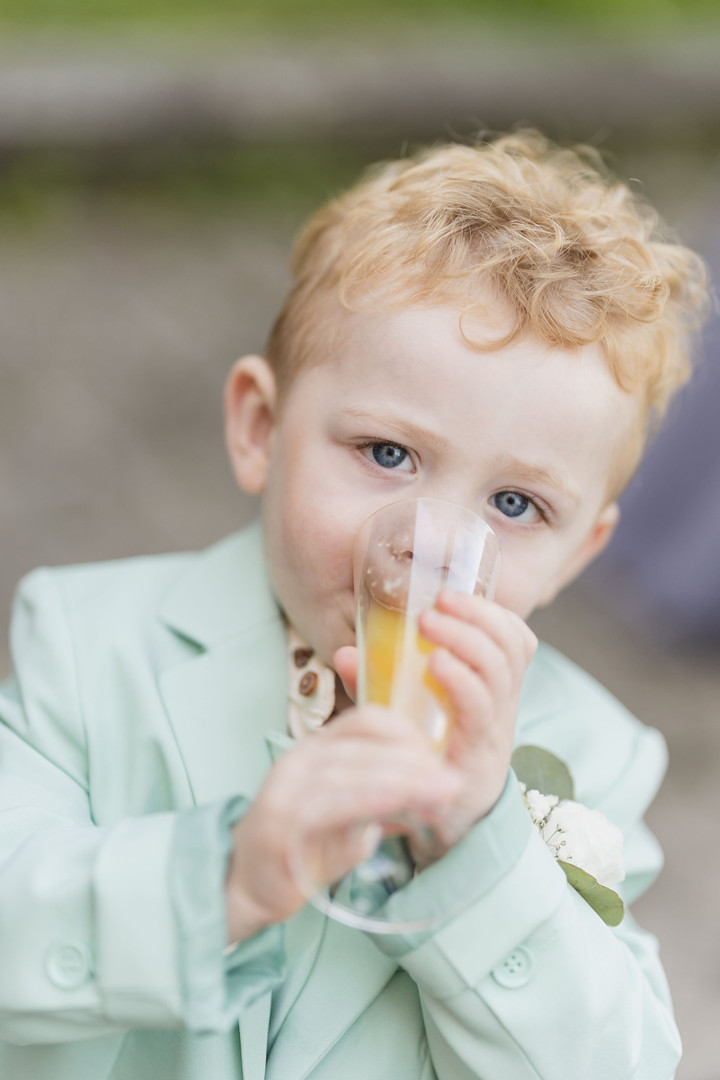 Hochzeit Kloster Wiblingen: Kleiner Junge im mintfarbenen Anzug trinkt beim Empfang aus einem Glas