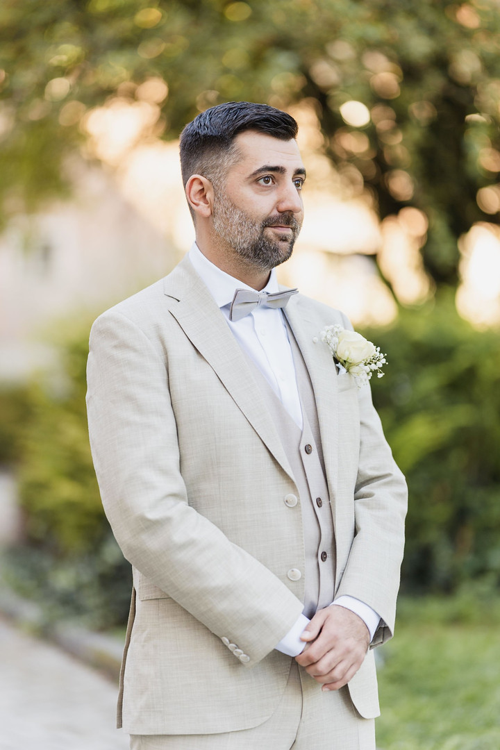 Hochzeit Kloster Wiblingen: Bräutigam im beigen Anzug beim Brautpaarshooting im Garten