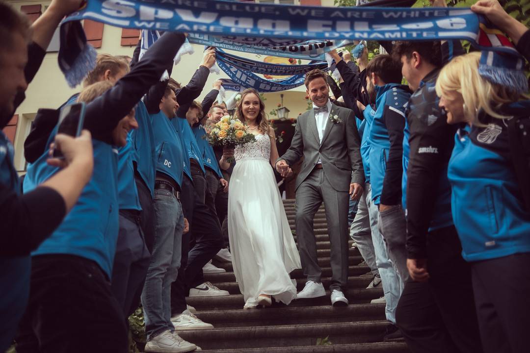 Hochzeit Standesamt Waldstetten: Brautpaar geht durch das Spalier mit Fanschals der SpVgg Ellzee die Treppe hinunter